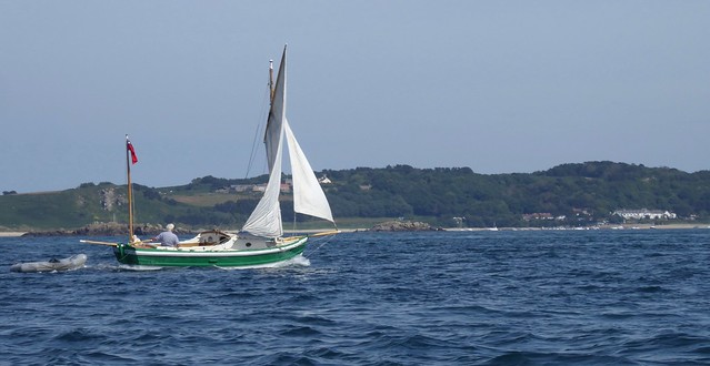 Green Sailing boat with herm in the background