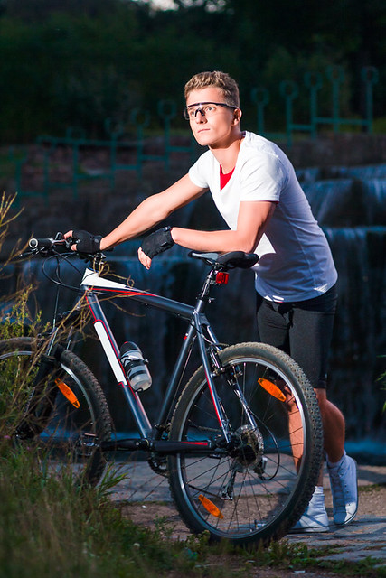 Healthy Lifestyle and Sport Concepts.Caucasian Male Athlete with Mountain Bike Posing Against Waterfall Outdoors.
