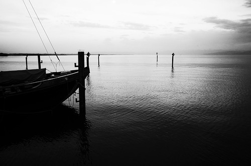 stefankamert water lake lakeconstance bodensee ship boat pole dark reflections noir noiretblanc blackandwhite blackwhite landscape horizon sky clouds ricoh gr grii