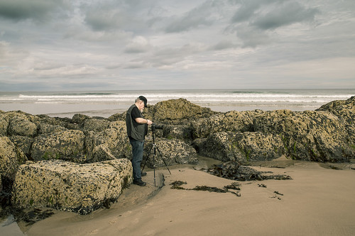 photographer beach rocks sand dramaticsky