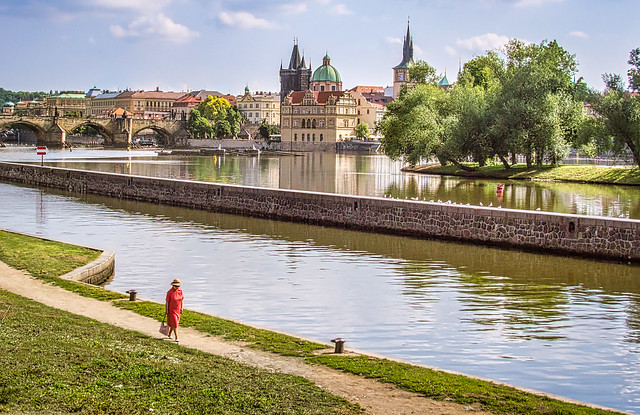 A woman walks by the River Vitava in Prague