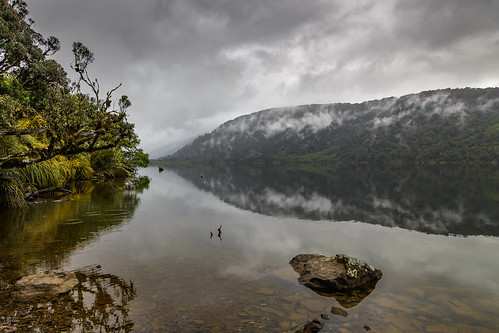 monrobeach lakemoeraki newzealand landscape reflections lake water clouds mountains trees rocks rainforest