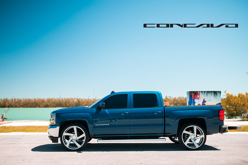 Side view of blue Chevy Silverado 1500 with empty blue sky in background
