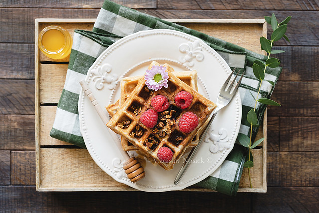 Belgian waffles with honey and raspberries for breakfast