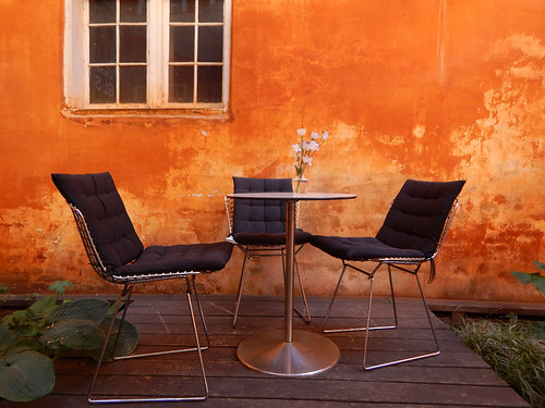 An orange wall with table and comfy chairs in Copenhagen, Denmark