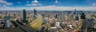 Aerial view of Bangkok skyline and skyscraper with BTS skytrain Bangkok downtown. Panorama of Sathorn and Silom business district Bangkok Thailand with blue sky and clouds.