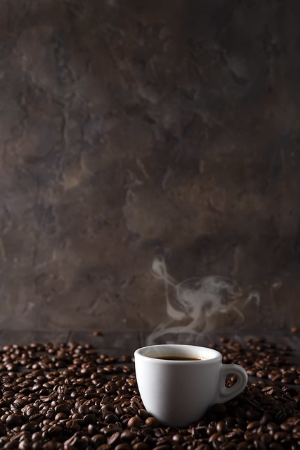 cup of hot coffee on the background of coffee grains on a dark wooden background, copy space