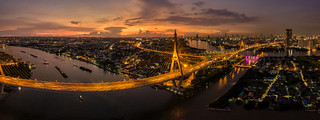 Aerial view of Bhumibol suspension bridge cross over Chao Phraya River in Bangkok city with car on the bridge at sunset sky and clouds in Bangkok Thailand.
