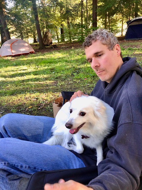 David cuddling Bella, American Eskimo dog