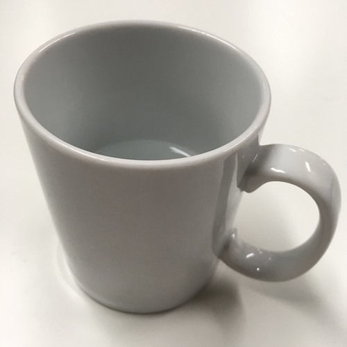 A photo of a plain white cylindrical mug.