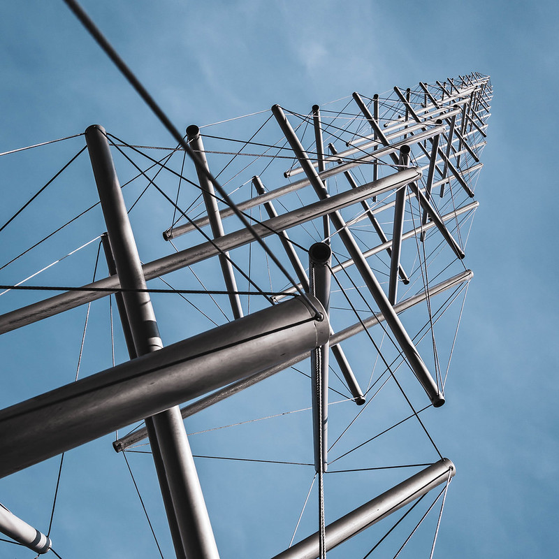 Tall tower with interconnecting poles and cables against a blue sky background