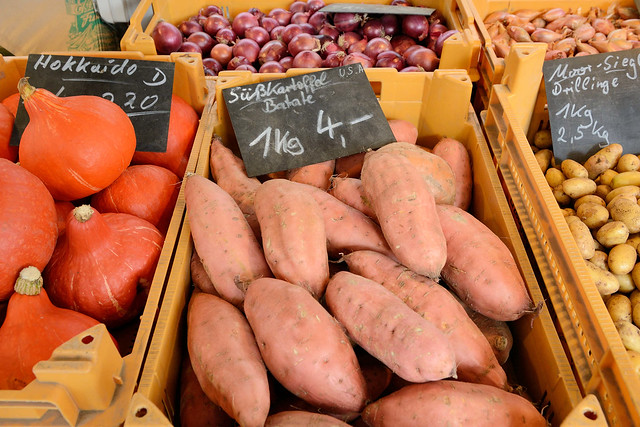 6970 Marktstand mit Süßkartoffeln / Batate und Kürbissen auf dem Wochenmarkt Straßburger Platz in der Dulsberg.