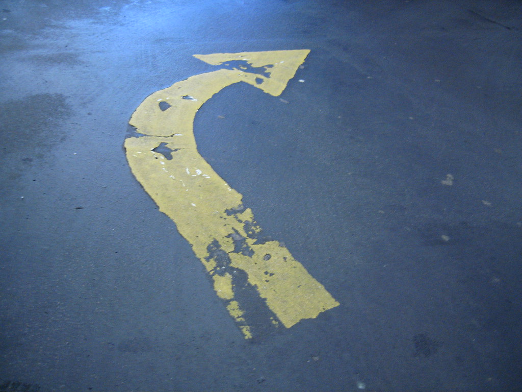 An arrow painted on a road. It is pointing to the right.