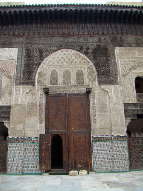 puerta de madera tallada azulejos arco estuco yeserías del patio interior Madraza Bou Inania de Fez Marruecos 05