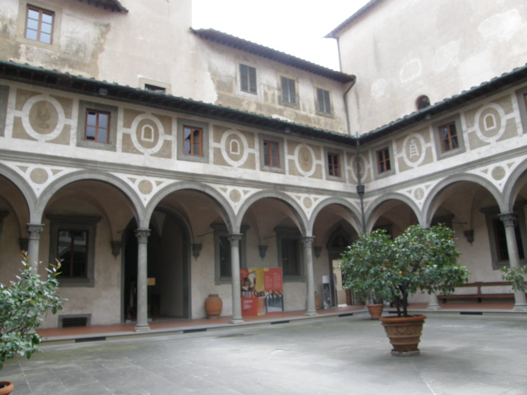 Firenze, lo Spedale degli Innocenti: A large structure with a courtyard in teh center and arches to the doors of the interior. 