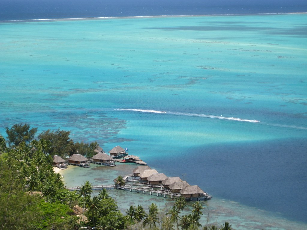 Overwater bungalows on stilts in the turquoise lagoon of Bora Bora