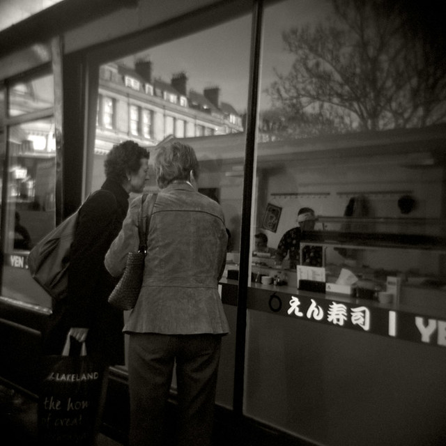 Curious Onlookers Ponder Over Yen Sushi, Bartlett Street, Bath.