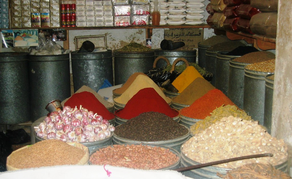 A colorful spice market stall in Morocco with baskets of ground spices