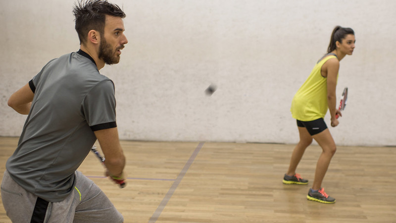 A man and a woman playing squash