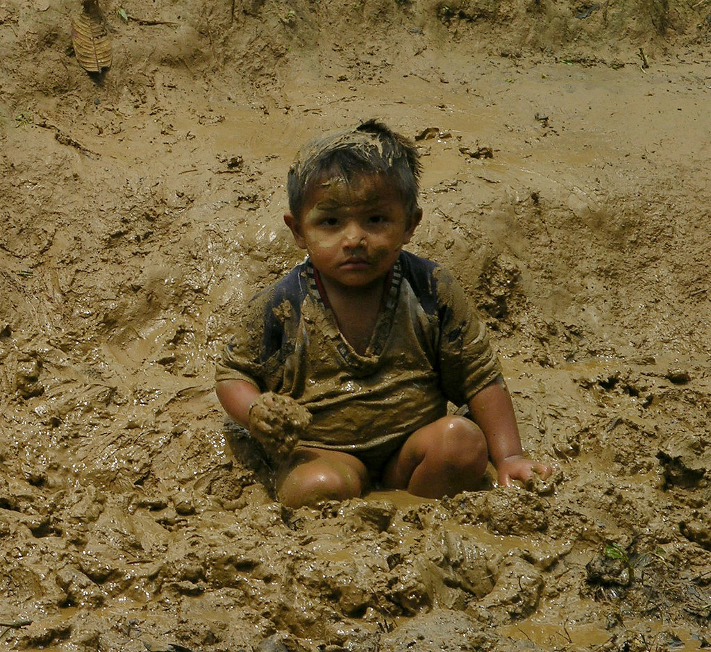 Indian kid playing in the mud