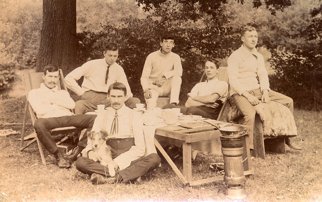 Six young men (and a dog) having a picnic
