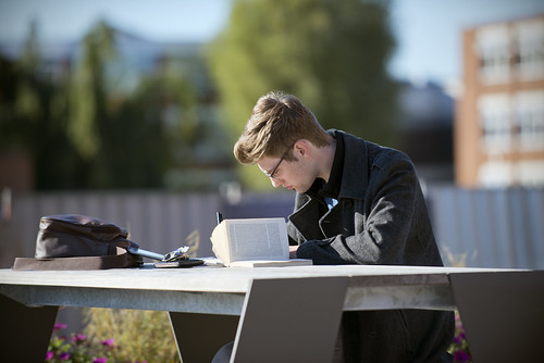 Male English Student Working Reading Outside Library BJL Exterior UNI_7982