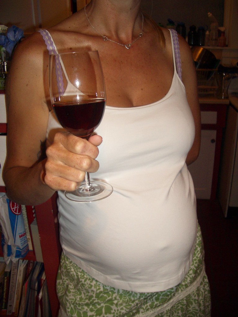 Alison with a wine glass and tummy