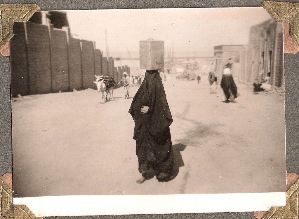 Kuwaitis woman in Kuwait carrying water in a can; about 1950.