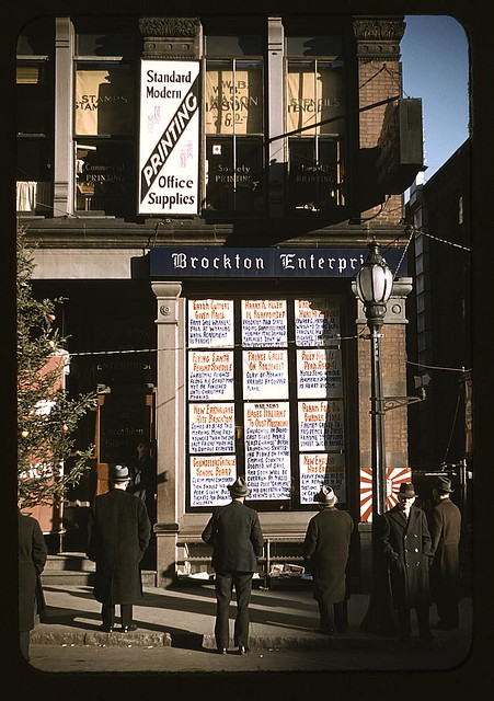 Men reading headlines posted in street-corner of Brockton Enterprise newspaper office, Brockton, Mass.  (LOC)