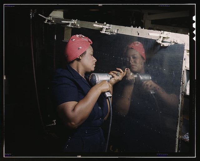 Operating a hand drill at Vultee-Nashville, woman is working on a 