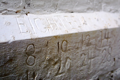 IMG_3986.JPG by Justin Masterson, Creeeeeepy writing, carved into a small nook in the exercise yard, where a patient could certainly w