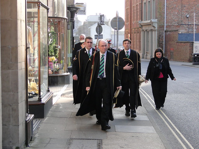 A sword and mace bearer leads council officials to the market place
