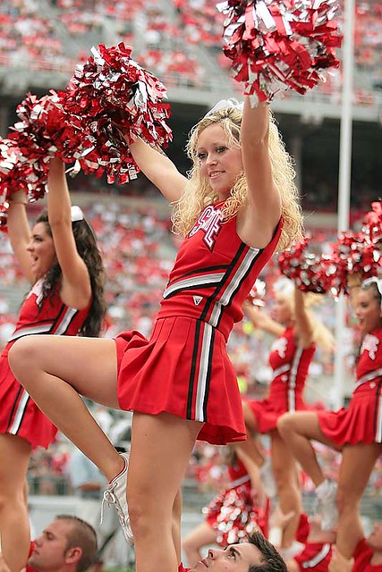 An Ohio State cheerleader lifts her knee in celebration of a buckeye's...