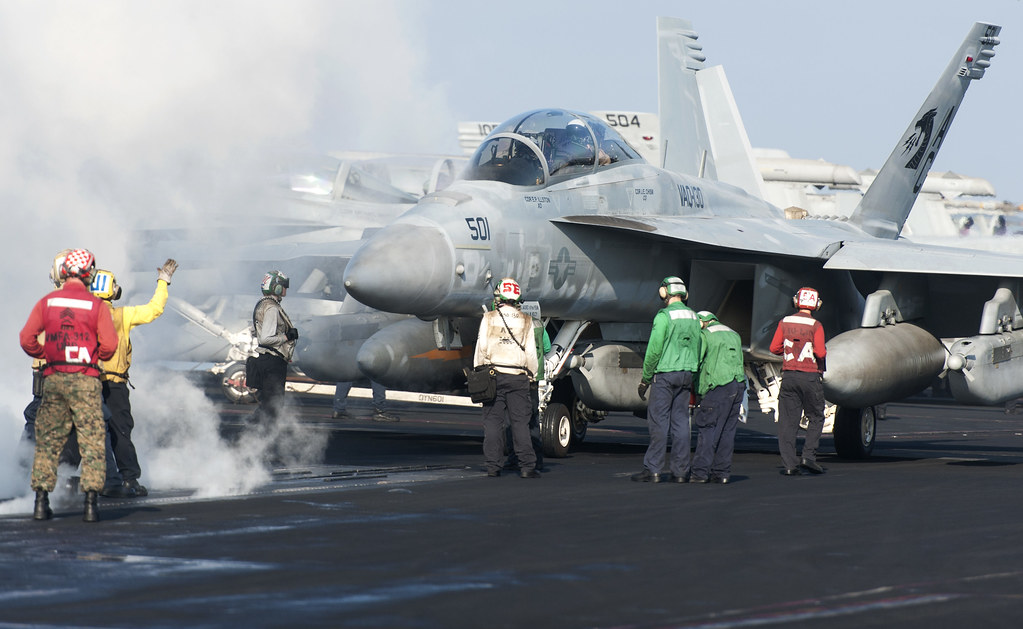 Sailors and Marines guide an EA-18G 