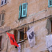 Bandeiras penduradas dunha cas en Corti / Autor: Guillaume Lucien Edouard