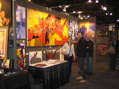 People standing among paintings at an exhibition