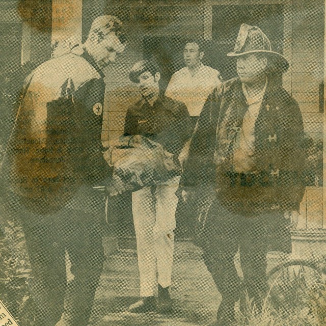Jim Moshinskie of Emerson & Son Funeral Home ambulance and Richard Jernigan of Langford's Mortuary ambulance carry out the victim of a home fire in Jonesboro, Arkansas, in 1970.