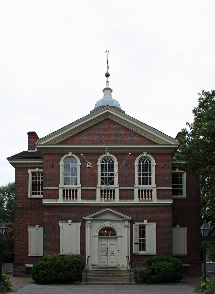 A tan building with white arched windows located in Philadelphia.