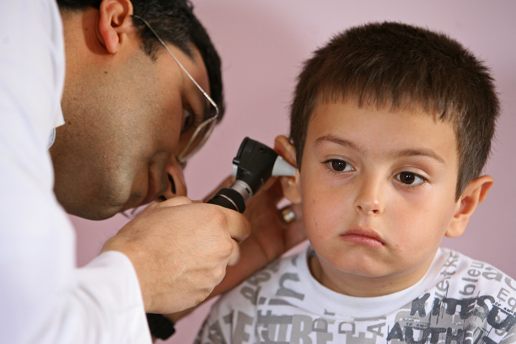 a child receives an ear exam as part of an overall health … | flickr