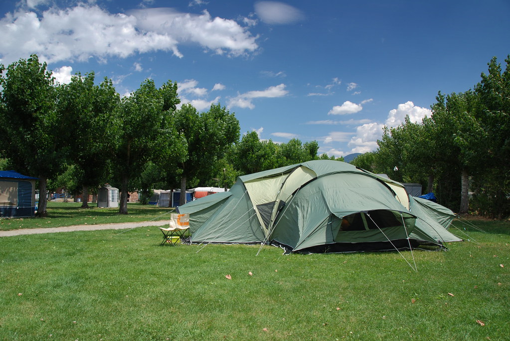 camping tent - a group of people sitting in a field with a view of the milky and the milky