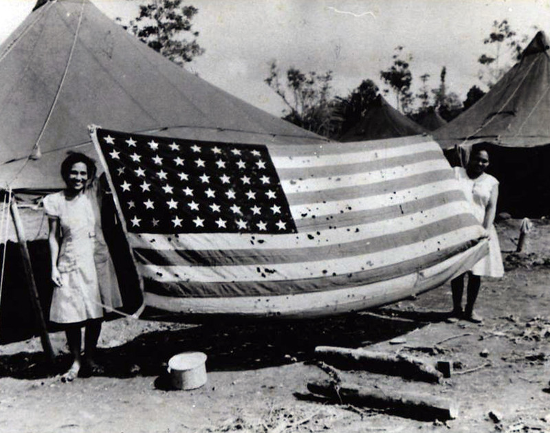 Chamorros hold up an American flag at a camp after Guam's Liberation from the Japanese, showing their feelings of patriotism.

Micronesian Area Research Center (MARC)