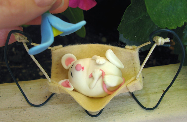 Cute sleeping mouse swaying in a hammock - miniature sculpture made of clay