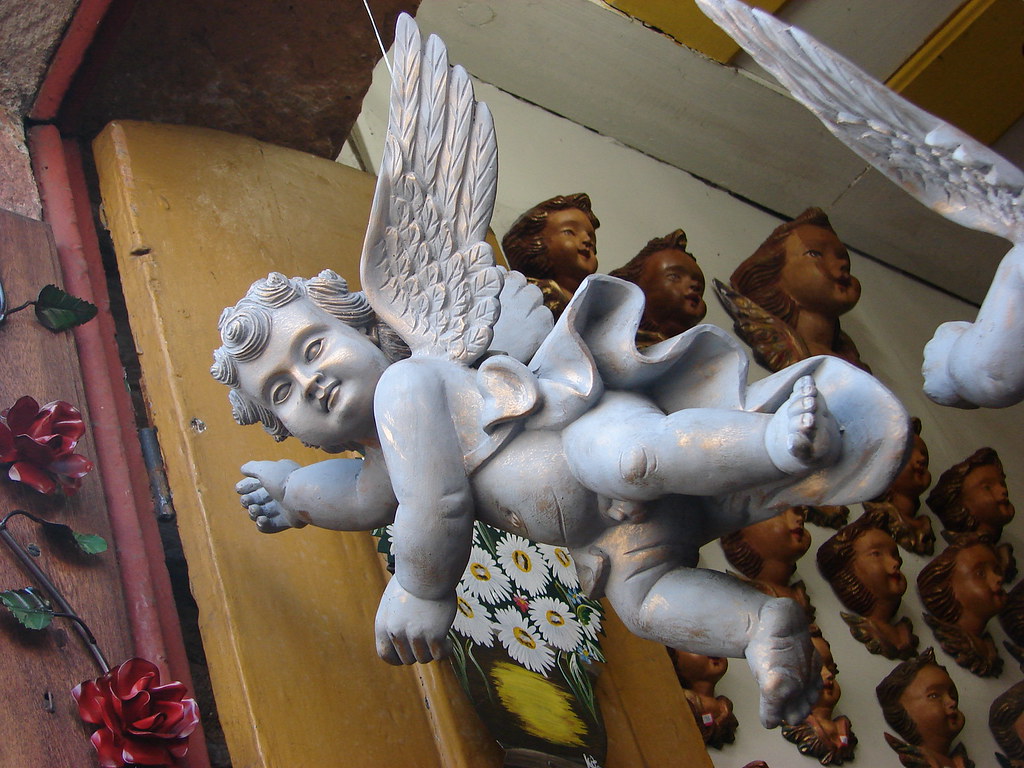 barrocos - a statue of a winged angel with a flower