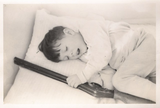Norman Berry Casas at Approx 5 years old in Bed with Toy Shotgun After Hard Day of Cowboy's and Indians