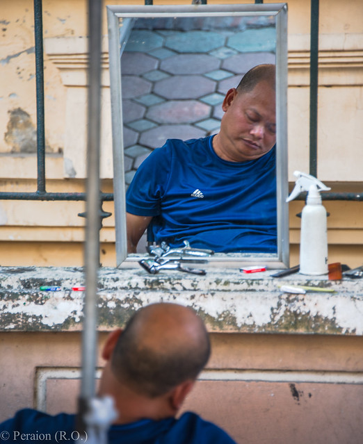 The dozing street barber during his siesta, Hanoi, Vietnam