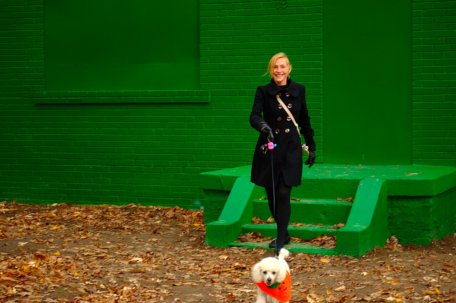 a pretty girl & her halloween dog in front of a green house