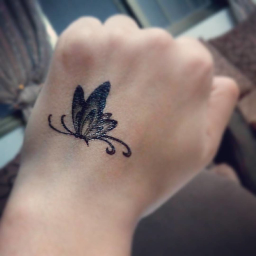 Small Black butterfly hand tattoo