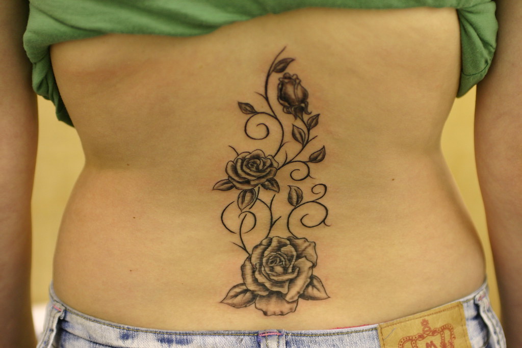 Roses and vines up spine tattoo.