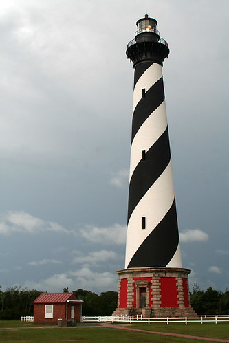 The Cape Hatteras Lighthouse in Buxton, NC by mikelynaugh, The Cape Hatteras Light House in Buxton, North Carolina on the Outer Banks during sunrise on a cloud