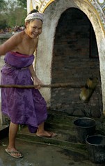 Woman getting water from well; NE of Galamba, Xishuangbanna Region, Yunnan, China
